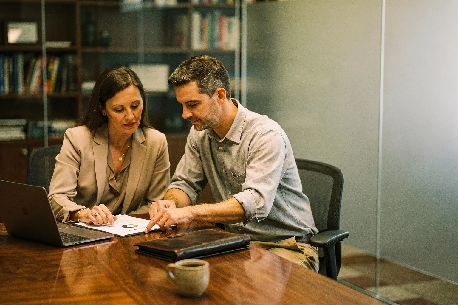 Two partners at a professional services firm reviewing a confidential client file at a conference table