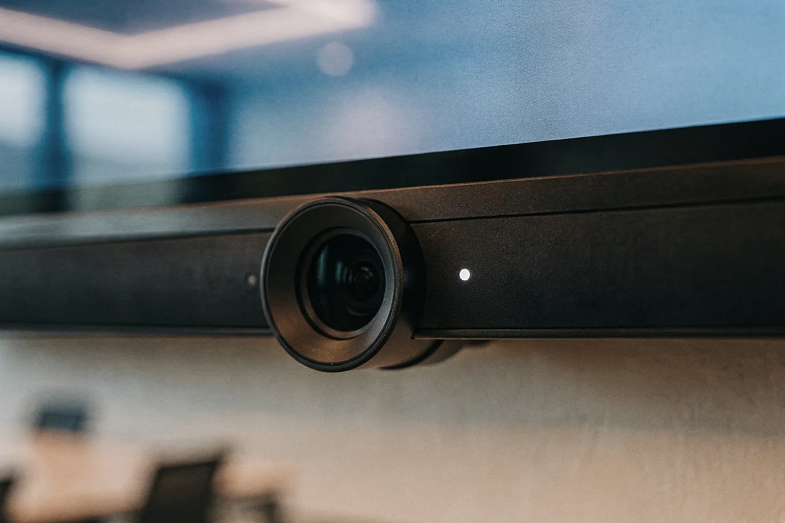 Close-up of a video bar camera mounted under a meeting room display